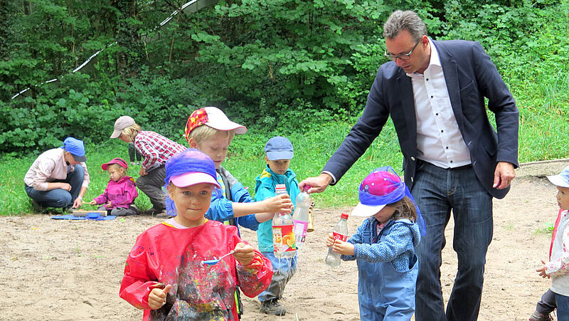 Beim Regenmachen: Die Kinder des Waldkindergartens und der Abgeordnete Dr. Joachim Pfeifer